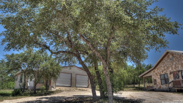 121 David Rankin Rd, Leakey, TX 78873 - view of property exterior featuring stone siding, dirt driveway, and entry steps