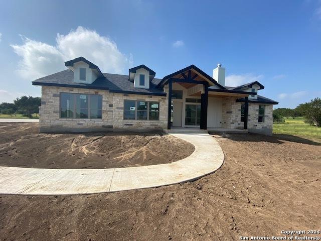 140 Horsehoe Fls, Bandera, TX 78003 - view of front of house with stone siding and a chimney