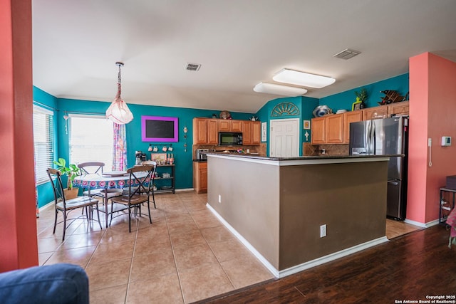 10715 Palomino, San Antonio, TX 78254 - kitchen with black microwave, freestanding refrigerator, dark countertops, and backsplash