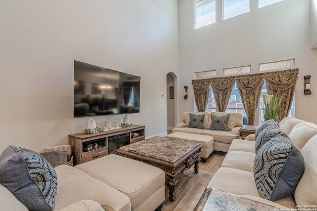 2564 Ayers, Seguin, TX 78155 - living room with arched walkways, light wood-style floors, a high ceiling, and baseboards
