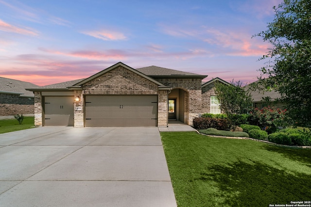 6038 Ballast Trl, New Braunfels, TX 78132 - french country style house featuring a garage, a yard, concrete driveway, a shingled roof, and brick siding