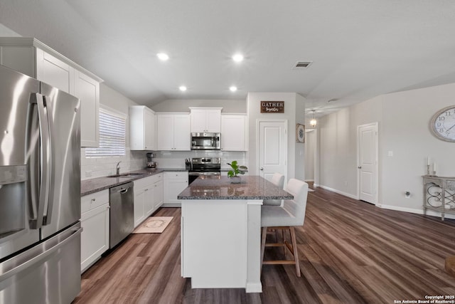 6038 Ballast Trl, New Braunfels, TX 78132 - kitchen with appliances with stainless steel finishes, a sink, a kitchen island, decorative backsplash, and dark wood-style floors