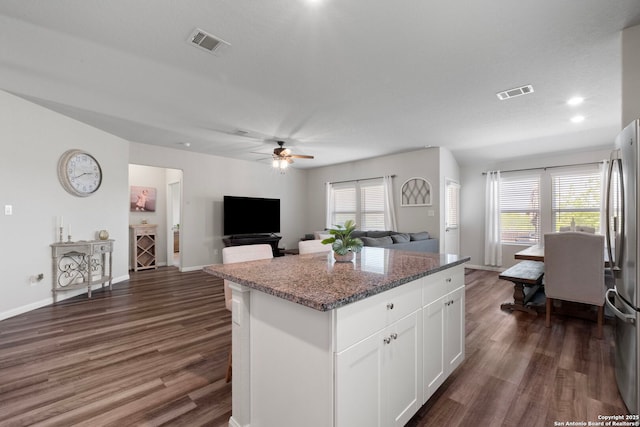 6038 Ballast Trl, New Braunfels, TX 78132 - kitchen featuring dark wood finished floors, a center island, stone countertops, freestanding refrigerator, and a ceiling fan