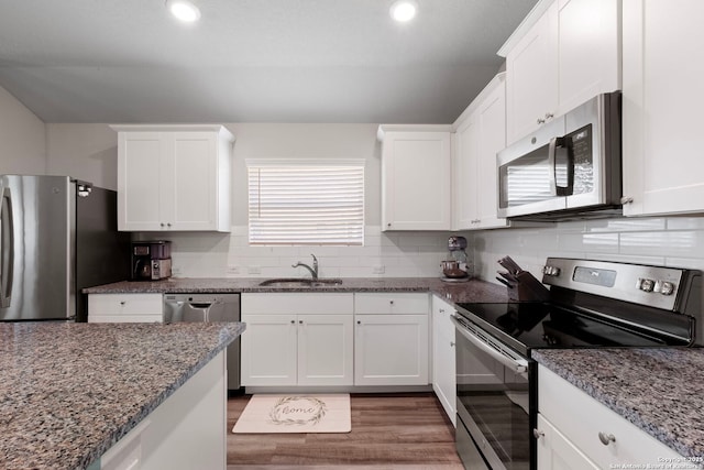 6038 Ballast Trl, New Braunfels, TX 78132 - kitchen with stainless steel appliances, a sink, white cabinetry, and recessed lighting