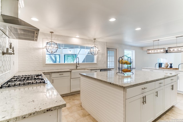 15021 Seven L Trl, Helotes, TX 78023 - kitchen featuring exhaust hood, a sink, a chandelier, stainless steel gas stovetop, and backsplash