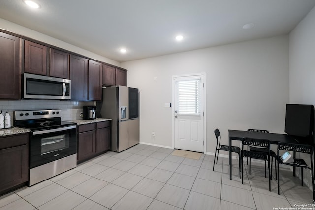 7731 Chatham, San Antonio, TX 78218 - kitchen with stainless steel appliances, dark brown cabinetry, tasteful backsplash, light stone countertops, and baseboards