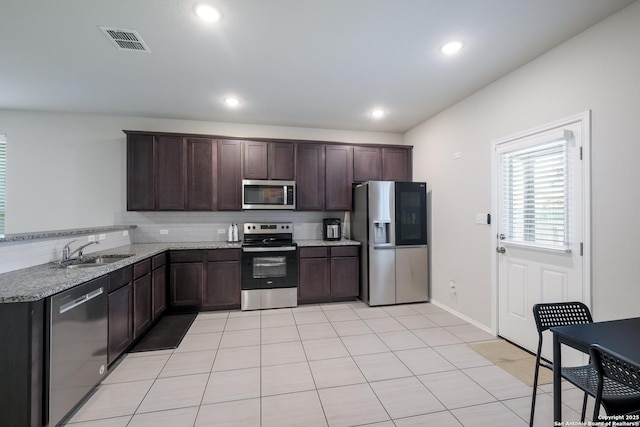 7731 Chatham, San Antonio, TX 78218 - kitchen with appliances with stainless steel finishes, a sink, dark brown cabinetry, light tile patterned floors, and recessed lighting