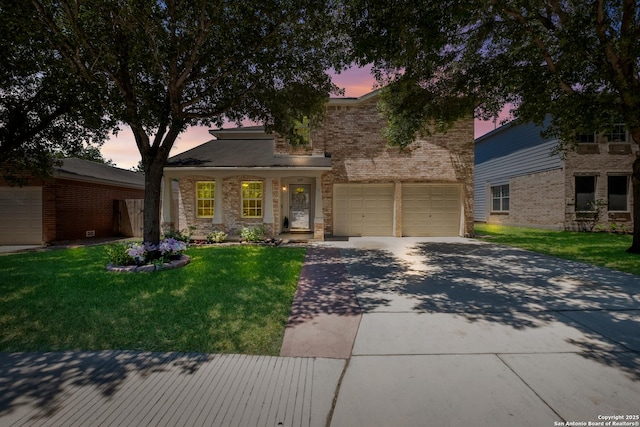 view of front of home with driveway, a lawn, brick siding, and an attached garage