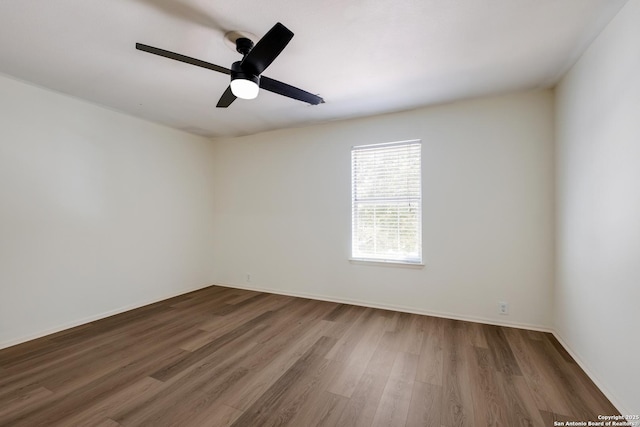 unfurnished room featuring wood finished floors, ceiling fan, and baseboards