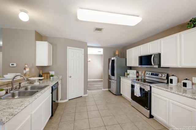 kitchen featuring appliances with stainless steel finishes, a sink, white cabinets, and baseboards