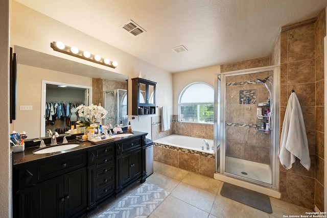 15206 Redbird Mnr, San Antonio, TX 78253 - bathroom featuring a shower stall, tile patterned floors, a garden tub, double vanity, and a textured ceiling