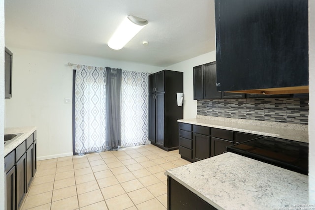 5107 Anacacho, San Antonio, TX 78217 - kitchen featuring backsplash, light tile patterned floors, black range with electric cooktop, and baseboards