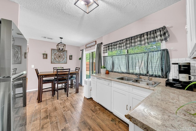 8239 Glen Lark, San Antonio, TX 78239 - kitchen featuring a sink, freestanding refrigerator, white dishwasher, a textured ceiling, and wood finished floors
