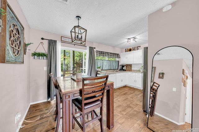8239 Glen Lark, San Antonio, TX 78239 - dining area with a textured ceiling, light wood-style flooring, and baseboards