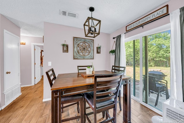 8239 Glen Lark, San Antonio, TX 78239 - dining area with a textured ceiling, light wood-type flooring, a chandelier, and baseboards