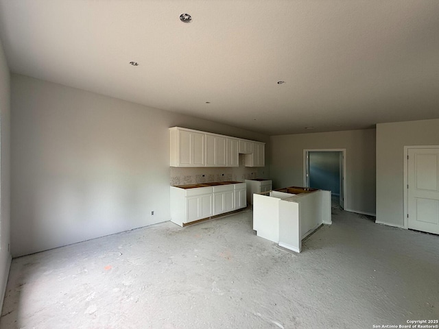 13726 Birch Xing, San Antonio, TX 78252 - kitchen featuring a center island, concrete flooring, and white cabinets