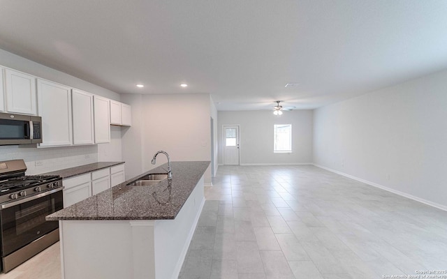 6726 Velma Path, San Antonio, TX 78253 - kitchen featuring stainless steel appliances, a sink, baseboards, dark stone countertops, and recessed lighting