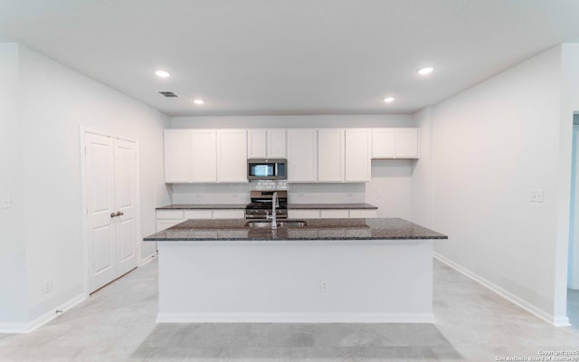 6726 Velma Path, San Antonio, TX 78253 - kitchen with stainless steel appliances, dark stone countertops, white cabinets, a center island with sink, and recessed lighting