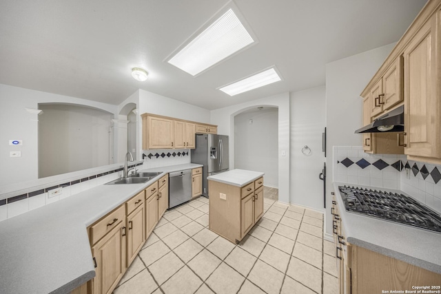 4726 Shavano Bark, San Antonio, TX 78230 - kitchen featuring appliances with stainless steel finishes, a sink, under cabinet range hood, light brown cabinetry, and arched walkways
