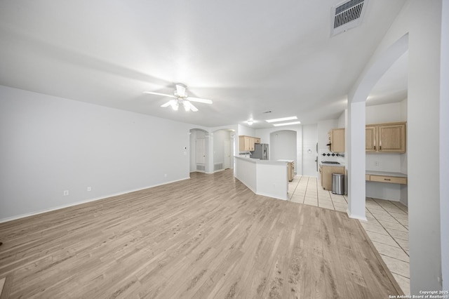 4726 Shavano Bark, San Antonio, TX 78230 - unfurnished living room featuring arched walkways, light wood-style floors, a ceiling fan, and baseboards