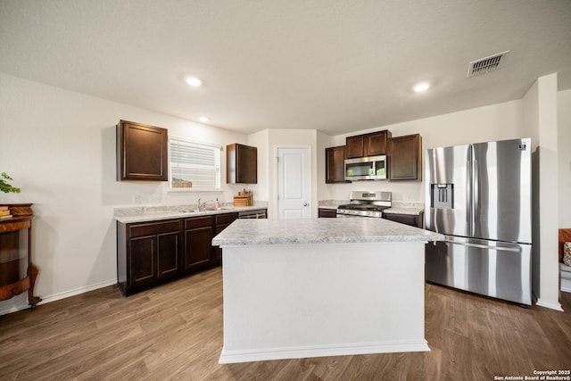 9827 Western Sedge, San Antonio, TX 78254 - kitchen featuring stainless steel appliances, a sink, dark brown cabinetry, light countertops, and recessed lighting