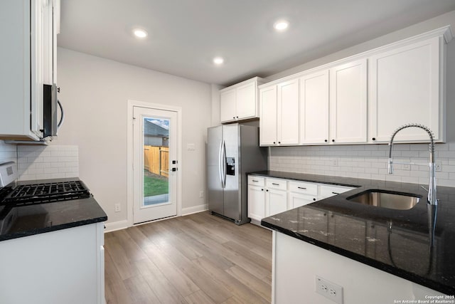 6620 Napa Fry, Converse, TX 78109 - kitchen featuring appliances with stainless steel finishes, a sink, dark stone counters, white cabinetry, and light wood-type flooring