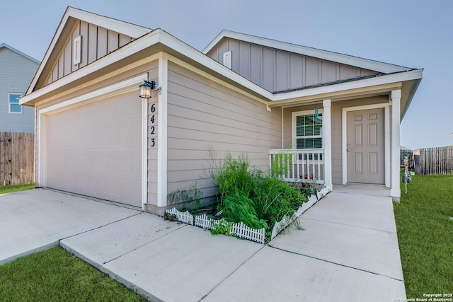 6423 Tractor, San Antonio, TX 78252 - view of front of house featuring board and batten siding, a porch, driveway, and fence