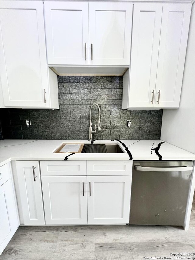 6427 Ridge Cir, San Antonio, TX 78233 - kitchen with stainless steel dishwasher, a sink, white cabinets, and decorative backsplash