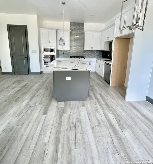 6427 Ridge Cir, San Antonio, TX 78233 - kitchen featuring appliances with stainless steel finishes, tasteful backsplash, a center island, and white cabinetry