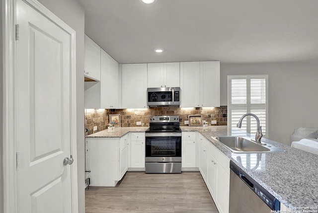 1919 Goldfinch, New Braunfels, TX 78130 - kitchen with appliances with stainless steel finishes, a sink, a peninsula, tasteful backsplash, and recessed lighting