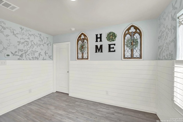 1919 Goldfinch, New Braunfels, TX 78130 - unfurnished room with wallpapered walls, wainscoting, wood finished floors, and plenty of natural light