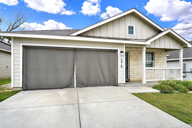 1919 Goldfinch, New Braunfels, TX 78130 - view of front of house with board and batten siding, driveway, a porch, a garage, and stone siding