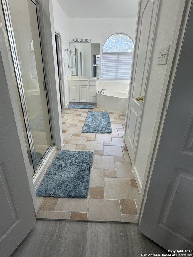 22722 Sabine, San Antonio, TX 78258 - full bathroom with a bath, a shower stall, vanity, and stone tile floors