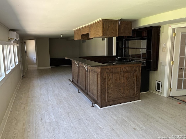 9570 Millers Rdg, San Antonio, TX 78239 - kitchen featuring baseboards, light wood-style floors, a wall mounted AC, and dark countertops