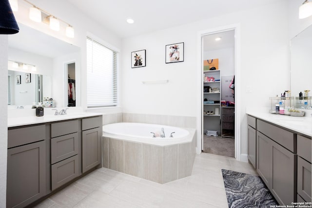 807 Swenson Rnch, San Antonio, TX 78245 - full bathroom with tile patterned flooring, a bath, a walk in closet, two vanities, and recessed lighting