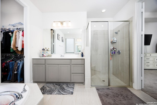 807 Swenson Rnch, San Antonio, TX 78245 - full bathroom with a stall shower, vanity, a walk in closet, a garden tub, and recessed lighting
