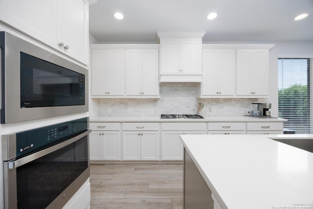 807 Swenson Rnch, San Antonio, TX 78245 - kitchen with oven, built in microwave, light countertops, white cabinets, and recessed lighting