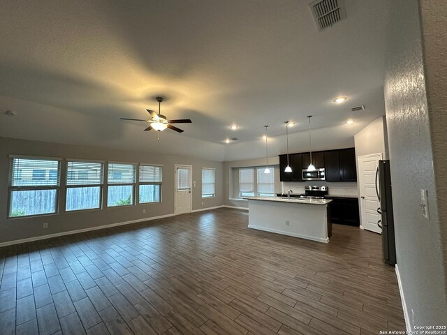 1116 Eagle, Seguin, TX 78155 - unfurnished living room with dark wood-style flooring, baseboards, ceiling fan, recessed lighting, and a sink
