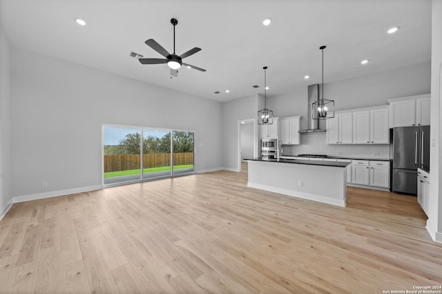 207 Azalea Aly, Castroville, TX 78009 - kitchen featuring stainless steel appliances, open floor plan, wall chimney exhaust hood, a sink, and dark countertops