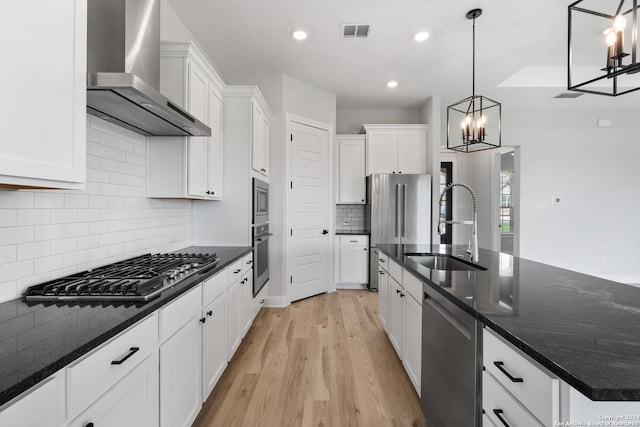 191 Azalea Aly, Castroville, TX 78009 - kitchen featuring wall chimney range hood, stainless steel appliances, a sink, light wood-style floors, and white cabinetry