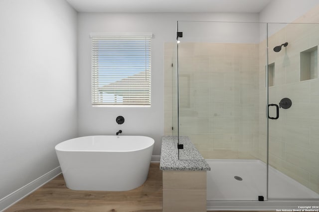 191 Azalea Aly, Castroville, TX 78009 - bathroom with a shower stall, a freestanding bath, baseboards, and wood finished floors