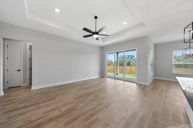 191 Azalea Aly, Castroville, TX 78009 - unfurnished living room featuring a raised ceiling, healthy amount of natural light, light wood-type flooring, and recessed lighting