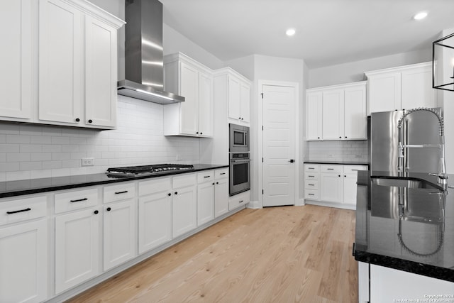243 Wisteria Vw, Castroville, TX 78009 - kitchen with wall chimney exhaust hood, stainless steel appliances, a sink, white cabinets, and recessed lighting