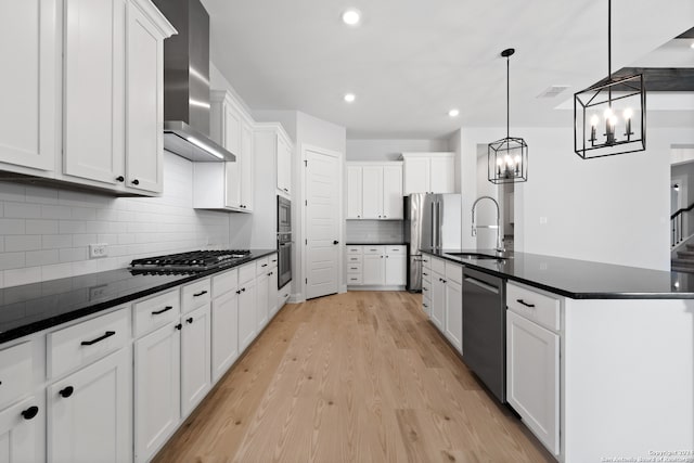 243 Wisteria Vw, Castroville, TX 78009 - kitchen featuring a sink, appliances with stainless steel finishes, wall chimney range hood, dark countertops, and a chandelier