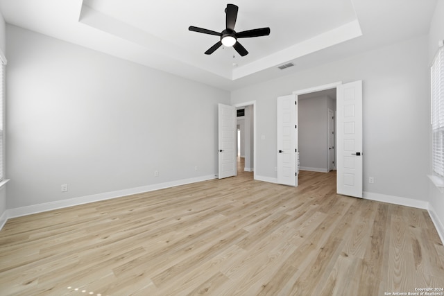 243 Wisteria Vw, Castroville, TX 78009 - unfurnished bedroom with a raised ceiling, light wood-style flooring, baseboards, and ceiling fan