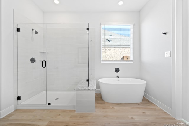 243 Wisteria Vw, Castroville, TX 78009 - bathroom with a stall shower, a freestanding bath, wood finished floors, baseboards, and recessed lighting