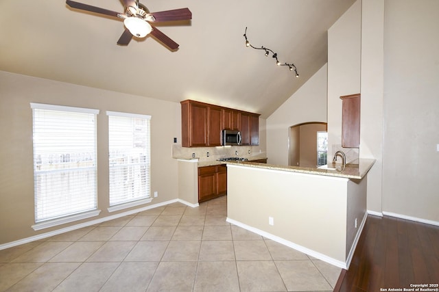 27218 Spiral Cyn, San Antonio, TX 78261 - kitchen with stainless steel appliances, backsplash, ceiling fan, high vaulted ceiling, and light stone counters