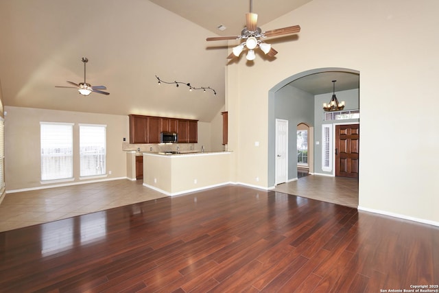 27218 Spiral Cyn, San Antonio, TX 78261 - unfurnished living room featuring high vaulted ceiling, a ceiling fan, arched walkways, a chandelier, and wood finished floors