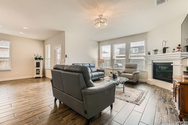 2215 Zachry, New Braunfels, TX 78132 - living room with wood finished floors, plenty of natural light, a glass covered fireplace, a chandelier, and recessed lighting