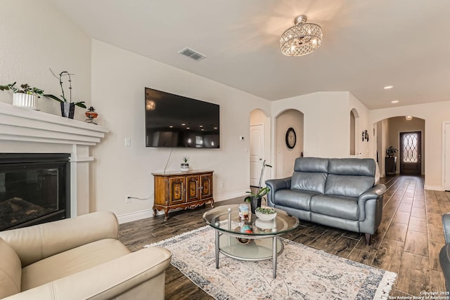2215 Zachry, New Braunfels, TX 78132 - living room with arched walkways, baseboards, wood finished floors, a glass covered fireplace, and recessed lighting